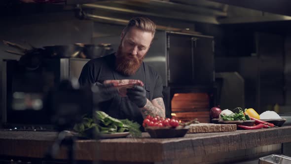 Bearded chef cook preparing steak in the restaraunt. 