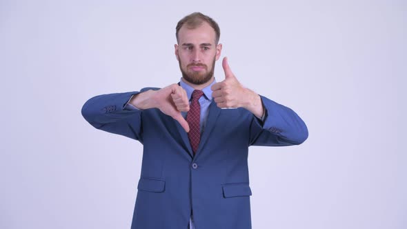 Confused Bearded Businessman Choosing Between Thumbs Up and Thumbs Down