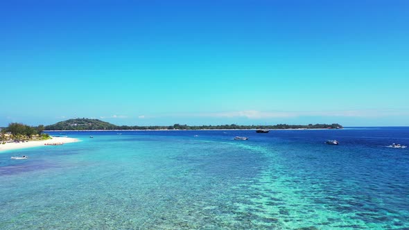 Beautiful healthy coral reef near the coast of tropical island, boats floating in the crystal clear alt