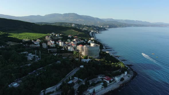 A Charming View of the Coastline of Alushta with Breakwaters and Clear Azure Sea Water and a Moving alt