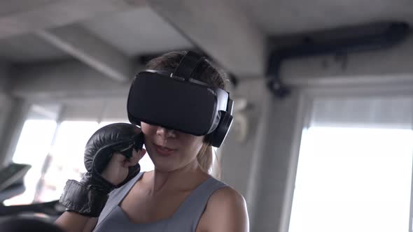 4K Asian sportswoman wearing VR glasses do boxing exercise workout at fitness gym.