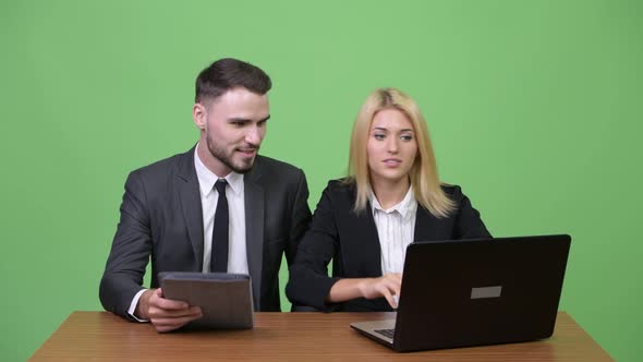 Young Happy Business Couple Using Laptop Together and Getting Good News