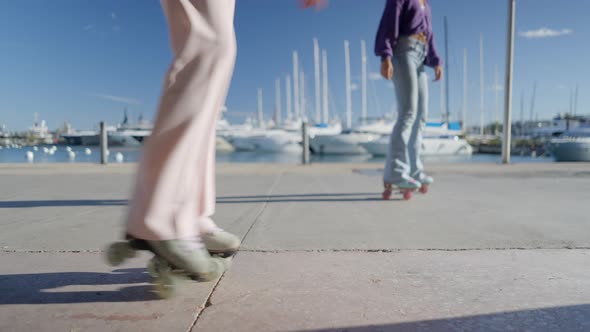Girl in Pink Pants Takes Steps on Retro Roller Skates By Boats Slomo alt