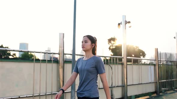 Young Asian woman athlete walking after a run.