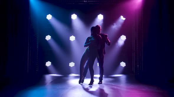 Concept of Social Dance and Relationships. Silhouette of Young Beautiful Couple Dancing Sensual alt