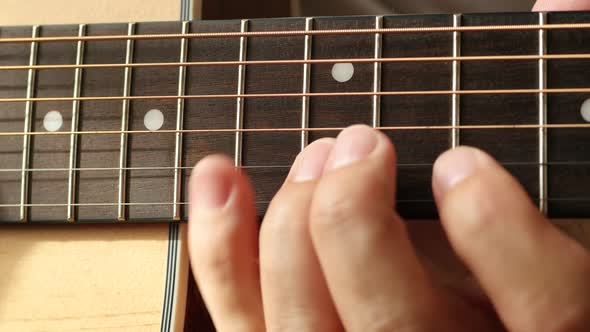 Fingers of a Musician on Guitar Fretboard Closeup alt