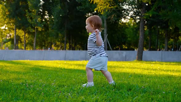 Cute Little baby girl walks by grass