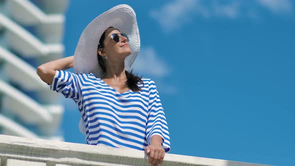 European Woman Having Vacation Enjoying Sunlight on Balcony of Modern Hotel alt