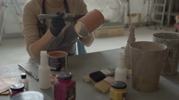 Young Woman Paints a Jar in a Creative Workshop