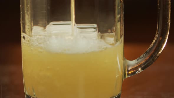 Beer pouring into a glass, foam goes up Close-up shot.