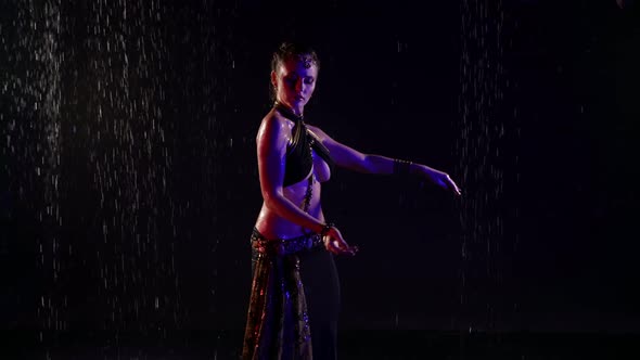 Professional Female Performer of Traditional Arabic Dance Woman is Dancing Under Rain in Darkness alt