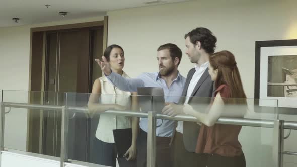 Team of colleagues discussing plans and looking at building interior alt