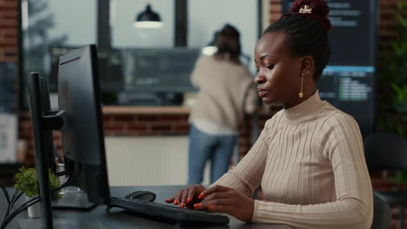 African American Software Engineer Working Focused Looking at Computer Screen While Typing alt