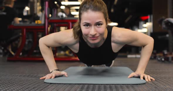 Young Sporty Woman Doing Pushups in the Gym