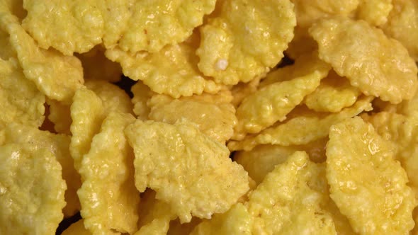 Crispy corn flakes rotating close up, dry healthy breakfast. Honey cornflakes for healthy cereal alt
