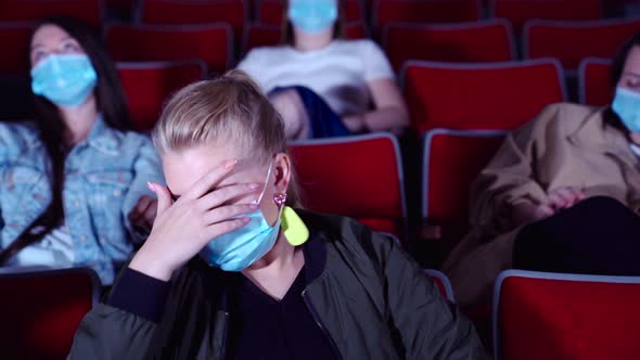 Young blond girl is terrified while watching a movie alt