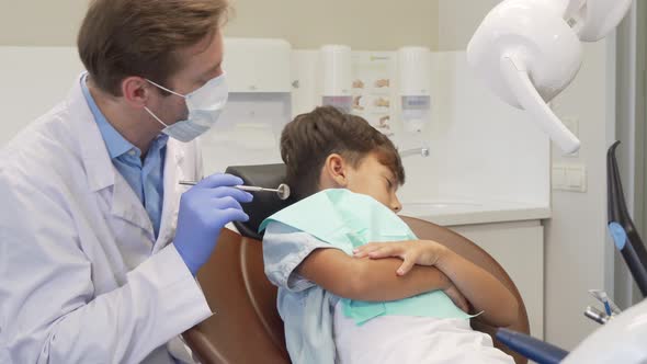 Little Cute Boy Refusing Showing His Teeth To the Dentist, Looking Sad and Scared alt