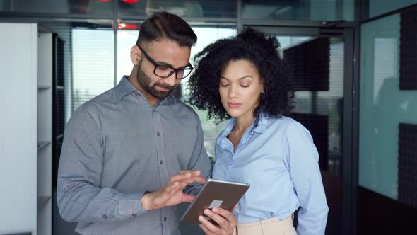 Multiracial Employees Colleagues Standing Using Tablet Device in Office alt