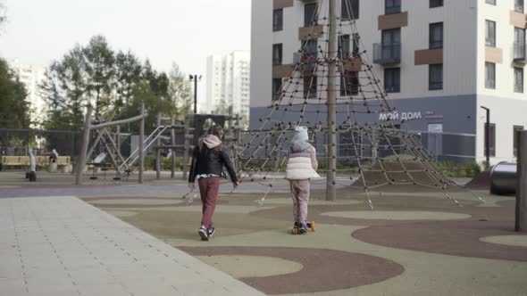 A boy and a girl walking on children playground alt