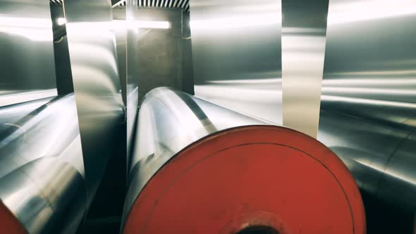 Sheets of Metal Material are Winding Through Large Reels alt
