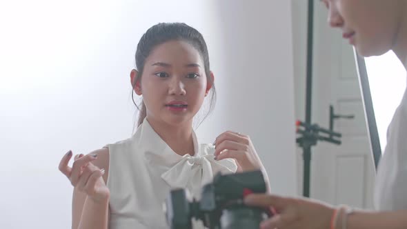 Young Asian Female Photographer Showing Photos To The Asian Model In Studio alt