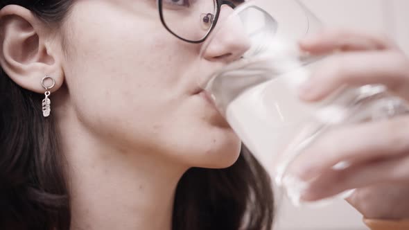 Brunette Teen Girl Drinking Water From a Glass and Smiling Closeup
