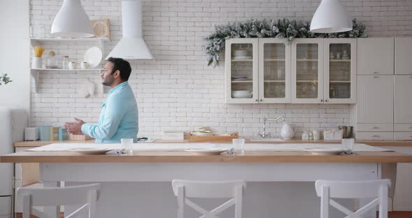 Latin American Man with Stubble Dances in Light Kitchen