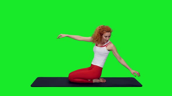 Flexible Slim Woman Stretching On Mat During Yoga On Green Screen alt