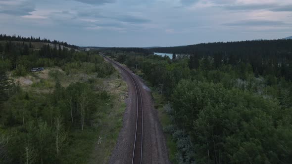 Empty train track running through the stunning landscapes of Kananaskis Country in Alberta, Canada. alt