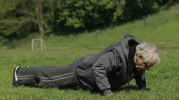 Active Senior Old Man Do Push-ups Physical Exercises in Sport Playground alt