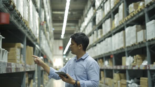 Man worker checking products with tablet in warehouse.