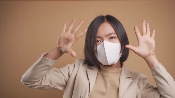 Close up shot of Asian business woman wearing hygienic mask and dancing isolated