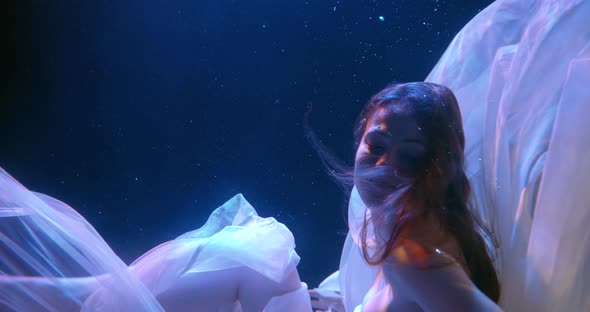 Portrait of a Beautiful Girl Under Water. She Sinks Into the Folds of the White Cloth, Lifts Her alt