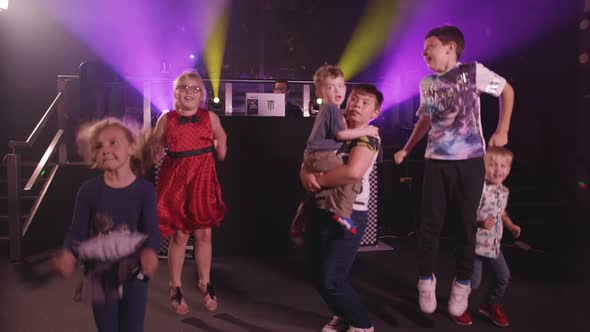 Kids Jumping Up and Down and Dancing at a Party With Bright Disco Lights alt