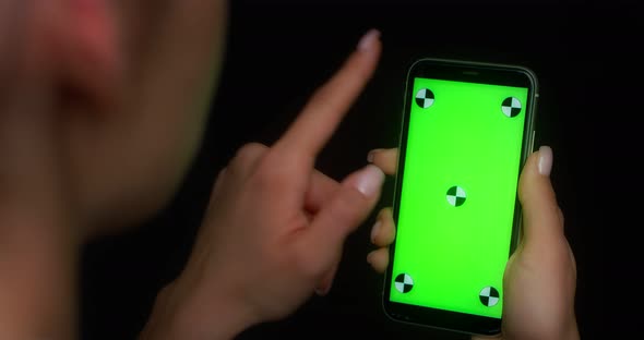Woman Using Mobile App on Green Screen Phone Swipes Up alt