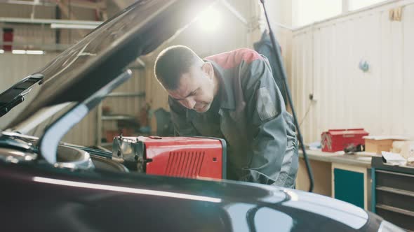 Car Mechanic in a Workshop Engine Repair and Diagnosis on a Vehicle alt