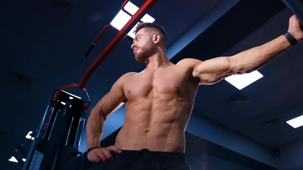 Muscular man over big gym background. Male with perfect naked torso. Slow motion alt