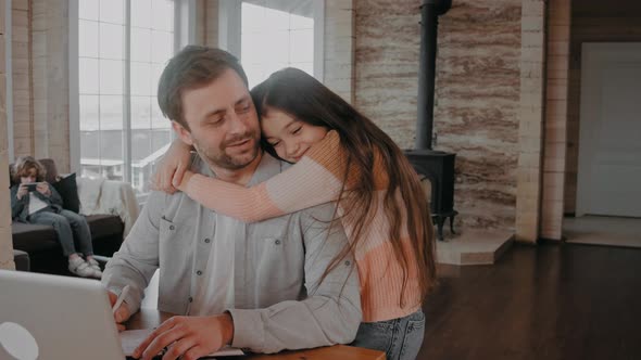 Girl Hugs Her Father While He is Working at Home Because of Covid Restrictions