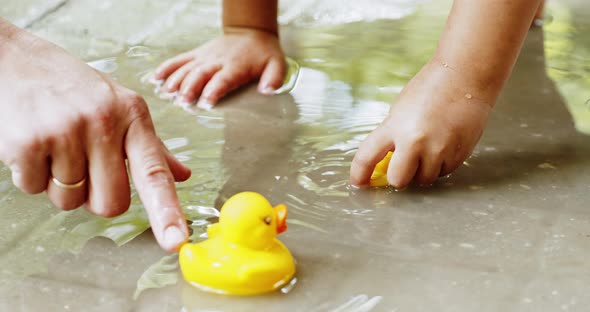 Mother and Child Play with Rubber Ducks alt