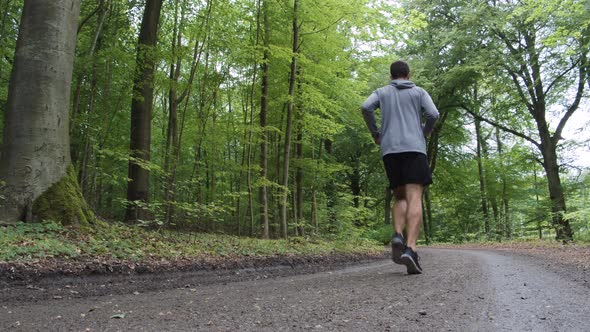 Athlete Running Through Forest