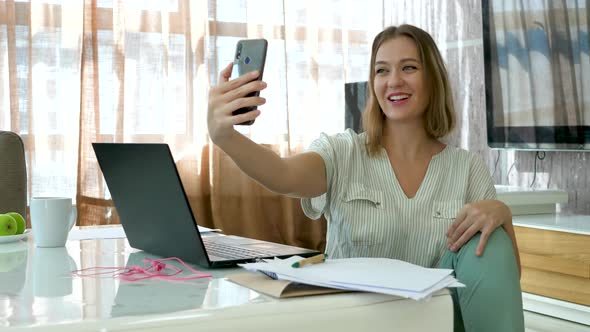 Pretty Woman Takes Selfie In Home Office With Smartphone