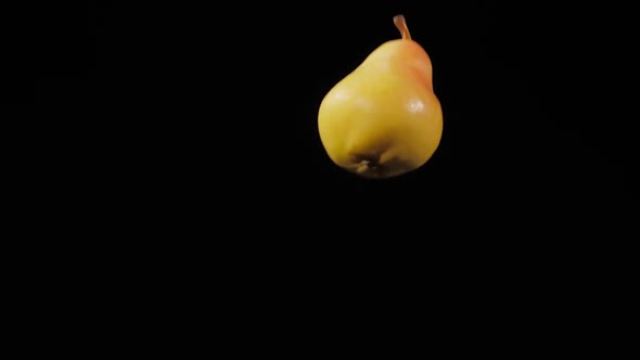 Close Up on the Two Fresh Juicy Pears Fly Up and Spinning on a Black Background in Slow Motion Shot alt