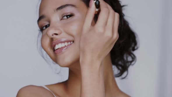 Beautiful Female Using Face Oil with Pipette and Moisturizing Her Cheeks alt