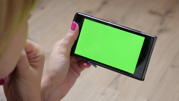 Modern woman holding green screen display mobile smart phone 4K 2160p 30fps UltraHD video - Female r alt