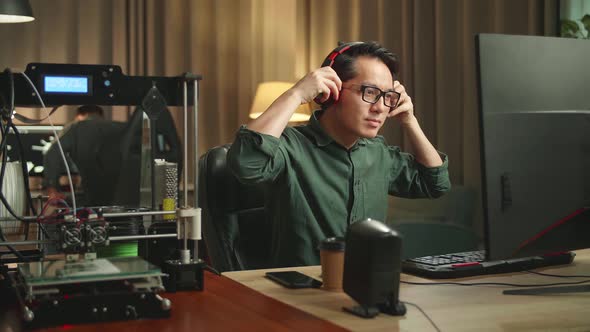 Asian Man Start Works On Personal Computer And 3D Printer In Home Office alt