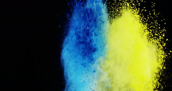 Blue and yellow dust powder blowing against black background alt