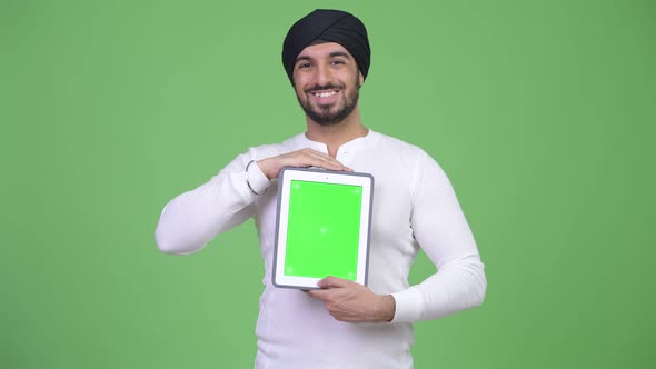 Young Happy Bearded Indian Man Showing Digital Tablet