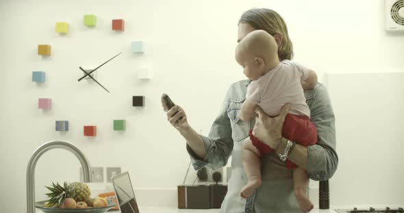 Father carrying daughter while talking on phone