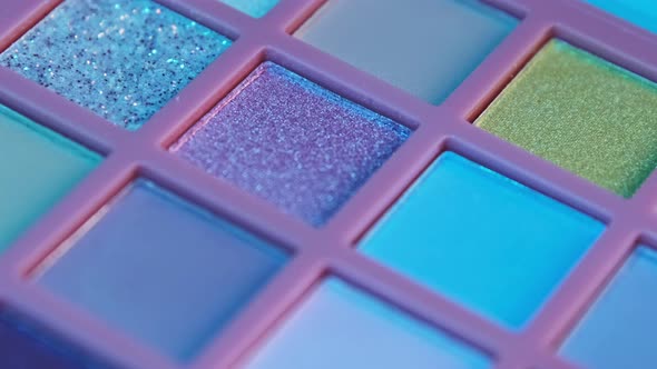 Make up pigment bright colorful eyeshadow palette in neon light. alt