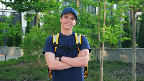 Camera Zoom in Smiling Young Man Courier Food Delivery with Thermal Backpack alt